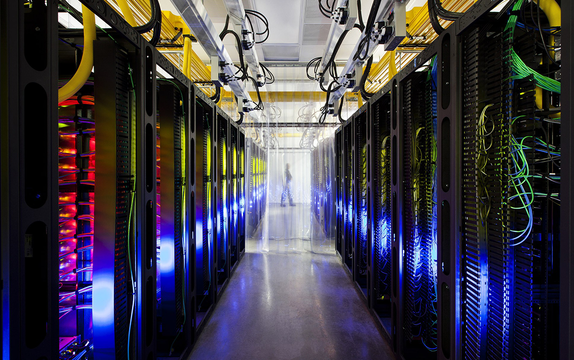 Data center aisle lined with server racks, status LEDs and fibre bundles