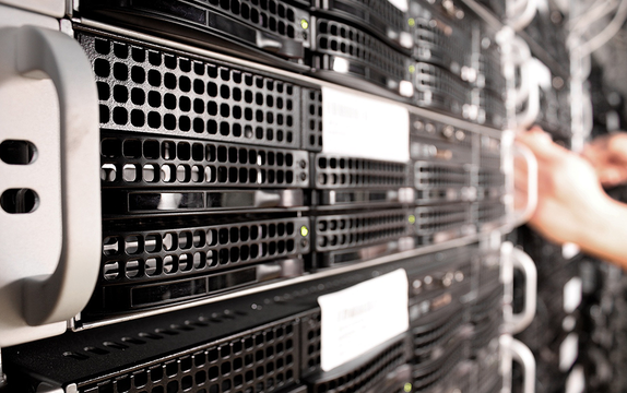 Close-up of rack-mounted servers with a technician working along the row